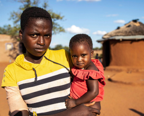 Thelma (1) is assessed during an Emergency Health Unit-supported nutrition survey in Zimbabwe (held by her sister Janet, 13). Image credit: Sacha Myers / Save the Children