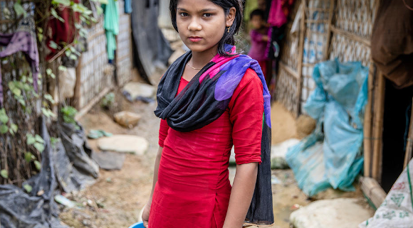 Marium*, 11, stands near her home in a camp for Rohingya Refugees in Cox’s Bazar, Bangladesh. Image credit: Jonathan Hyams / Save the Children UK Stories Team