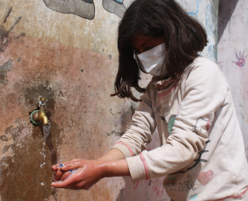 Tala*, 9 washing her hands. Image credit: GMU