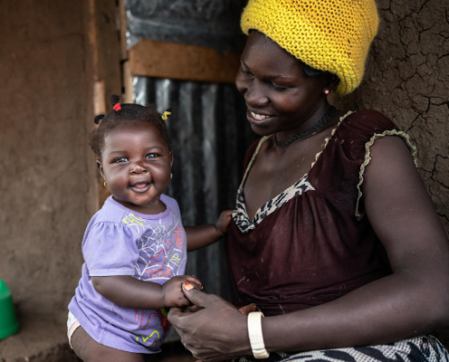 Isabella* is playing with her baby Cecilia* outside their home. Image credit: Fredrik Lerneryd / Save the Children