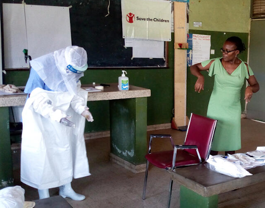 Participant health workers shown how to wear and use Personal Protective Equipment at training of health workers in Western Uganda. Image credit: Annet Kabasinguzi / Save the Children