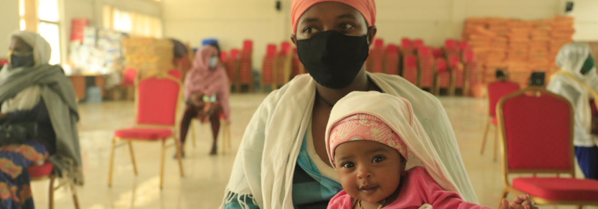 Zenebech,* mother of three, with her youngest child at an emergency food assistance gathering in Addis Ababa, Ethiopia in August, 2020. (Misak Workneh / Save the Children)