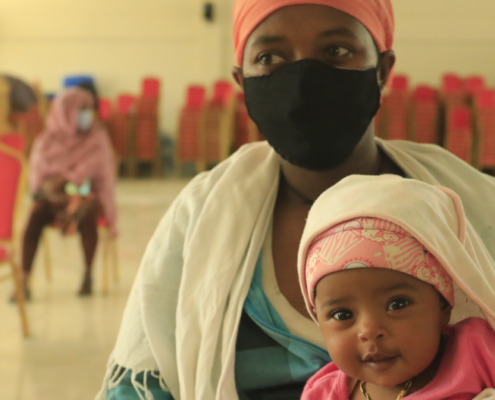 Zenebech,* mother of three, with her youngest child at an emergency food assistance gathering in Addis Ababa, Ethiopia in August, 2020. (Misak Workneh / Save the Children)