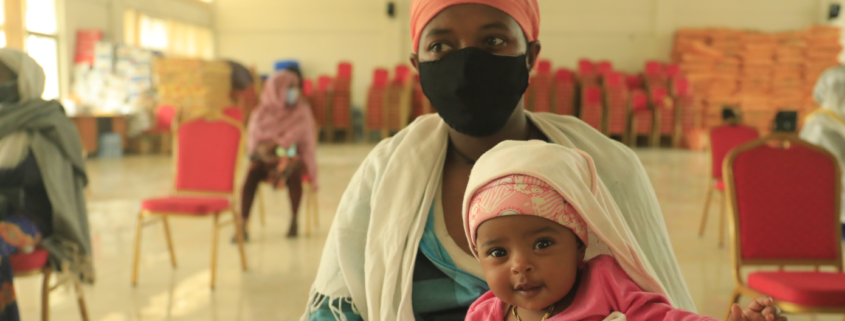 Zenebech,* mother of three, with her youngest child at an emergency food assistance gathering in Addis Ababa, Ethiopia in August, 2020. (Misak Workneh / Save the Children)